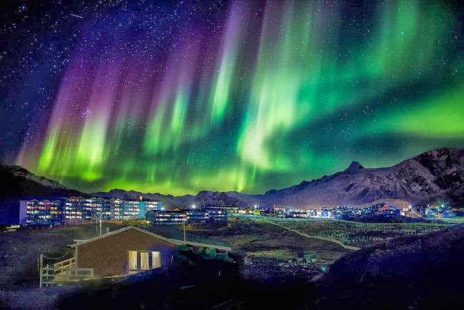 Una fantastica aurora boreale su una cittadina.