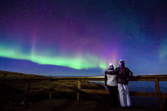 Una coppia guarda la stupefacente aurora boreale.