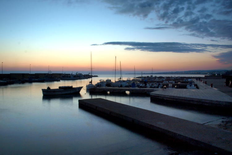 Foto lunga esposizione al tramonto in un porto.