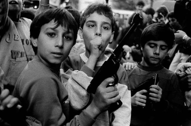 Foto di Letizia Battaglia, bambino con pistola giocattolo.